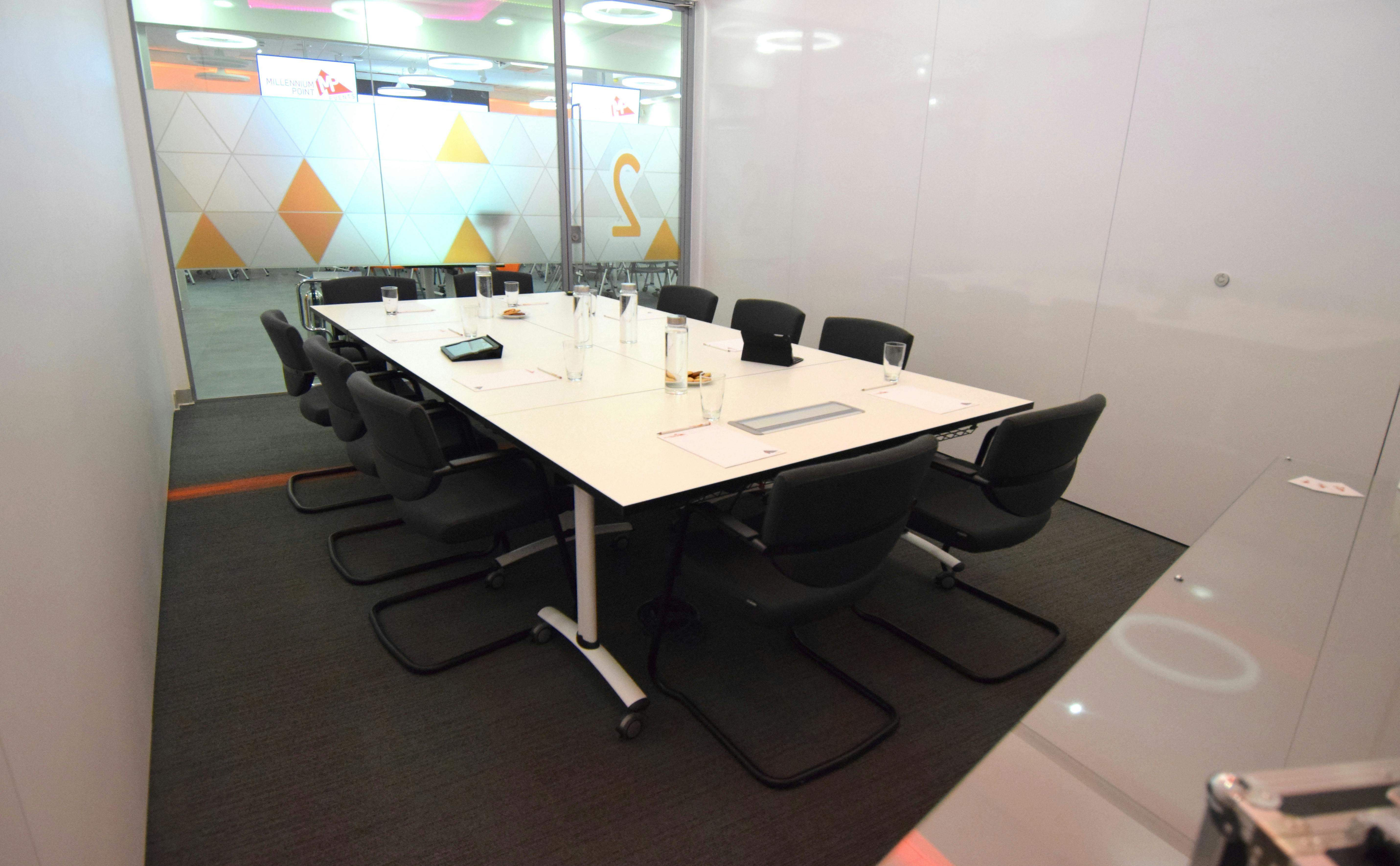 Modern conference room with glass walls for collaborative meetings at Millennium Point.