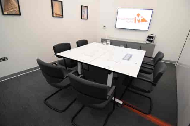 Modern meeting room with glass table, ideal for professional gatherings and presentations.