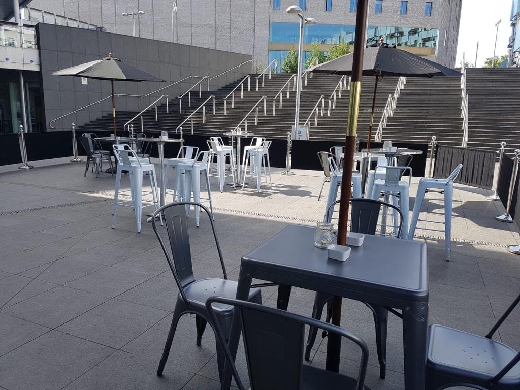 Modern outdoor event space at INGRESS, featuring metal furniture for gatherings.