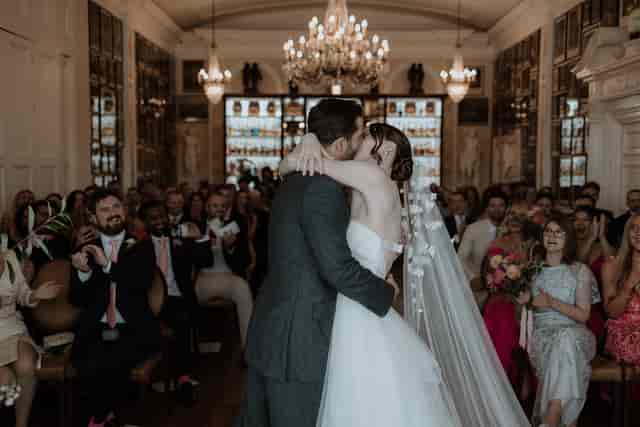 Intimate wedding ceremony in Nelson Room, Trafalgar Tavern, capturing couple's first kiss.