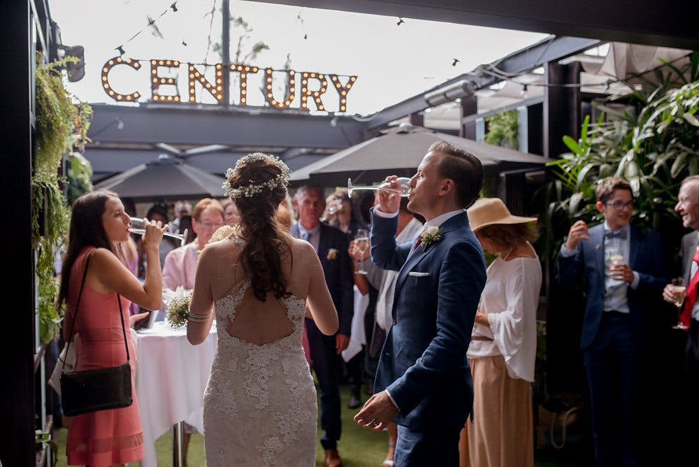 Rooftop terrace wedding reception with retractable glass roof and string lights.