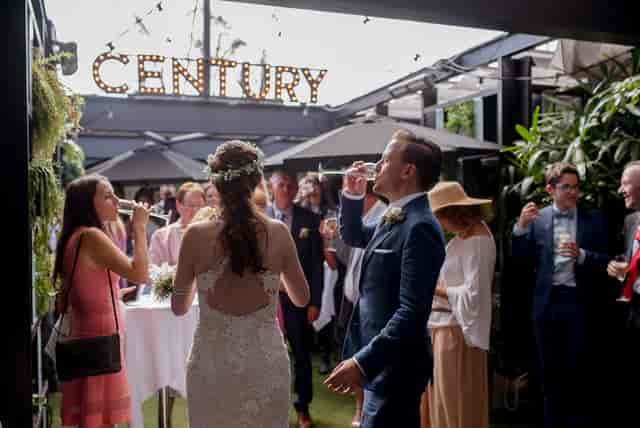 Rooftop terrace wedding reception with retractable glass roof and string lights.