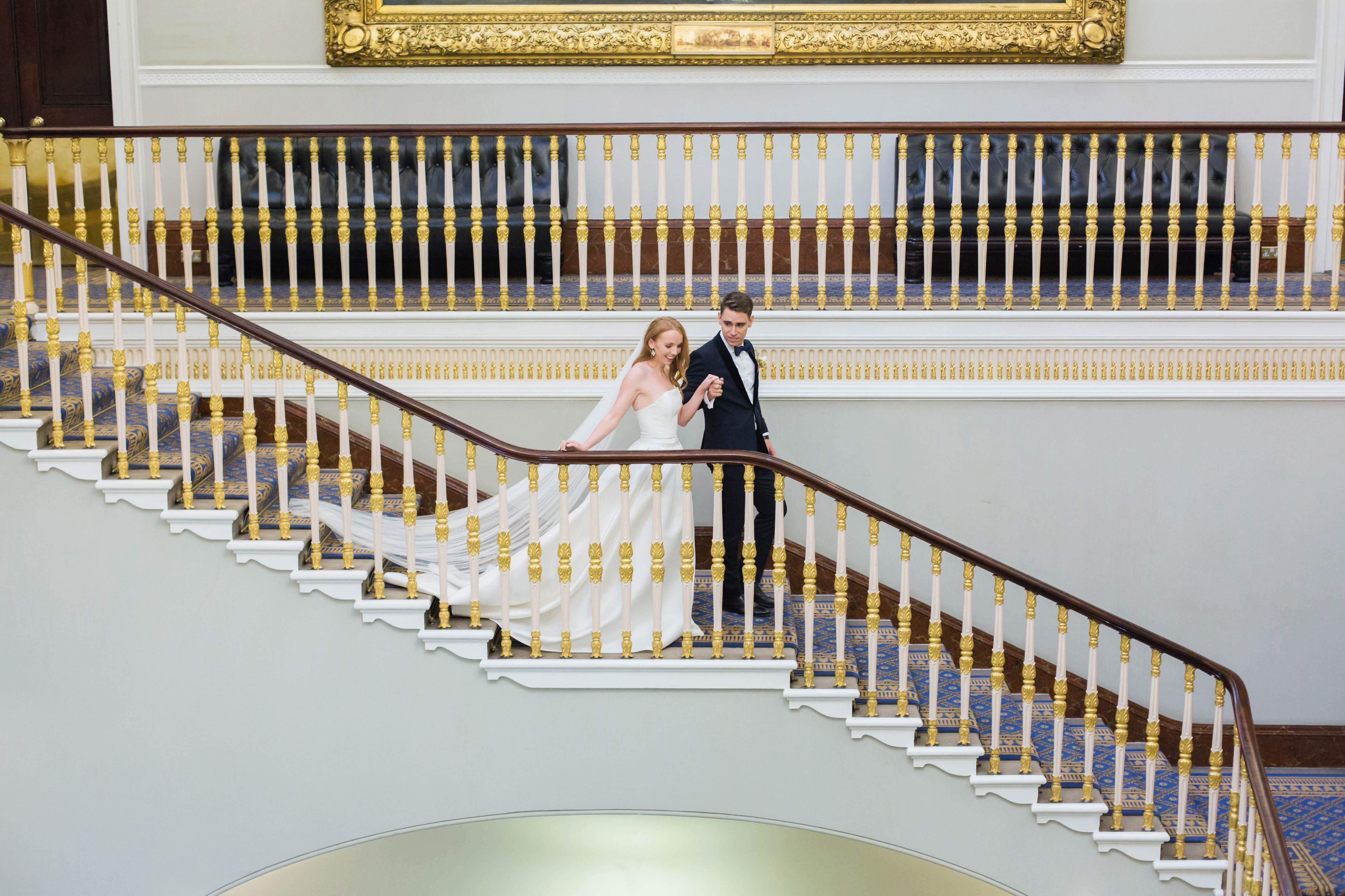 Elegant couple ascending grand staircase at Carlton Room, perfect for weddings and upscale events. - Banner