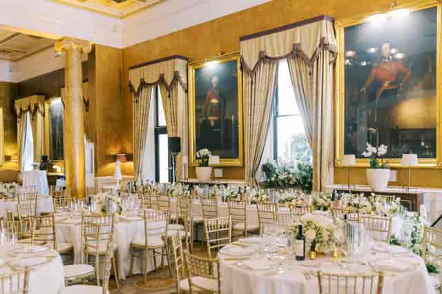 Gala dinner, opulent ballroom, ornate pillars, floral decor.