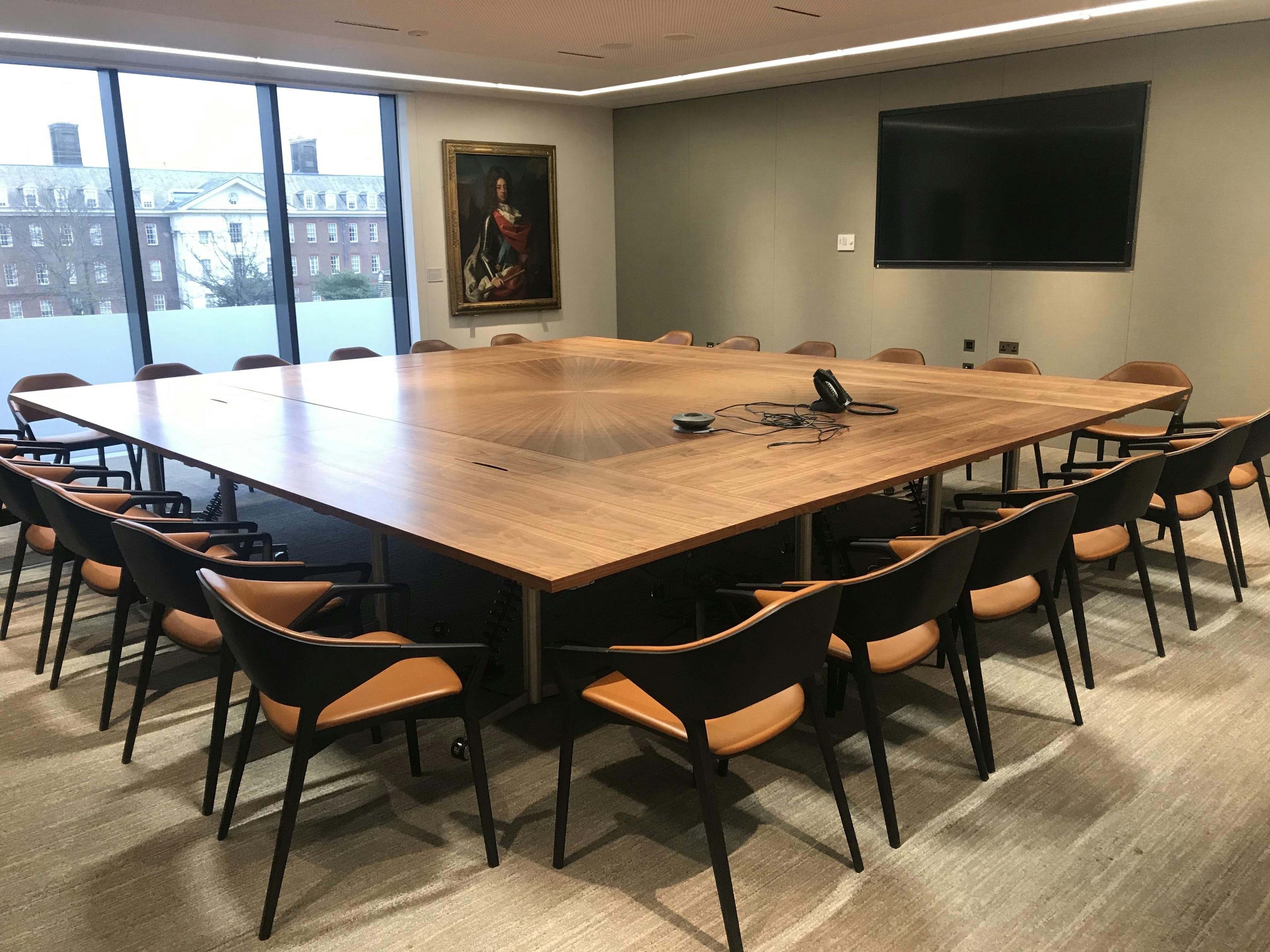 Modern boardroom with wooden table, ideal for conferences and presentations.