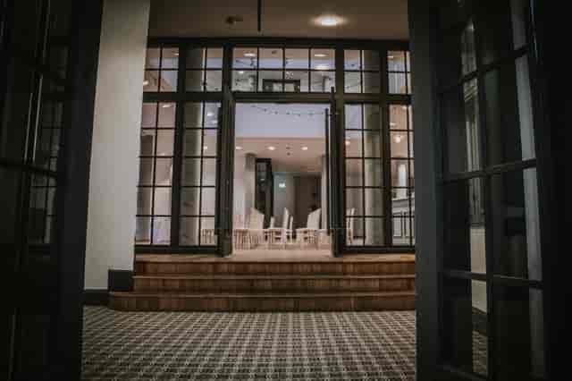 Elegant event space entrance with glass doors, ideal for meetings and gatherings.