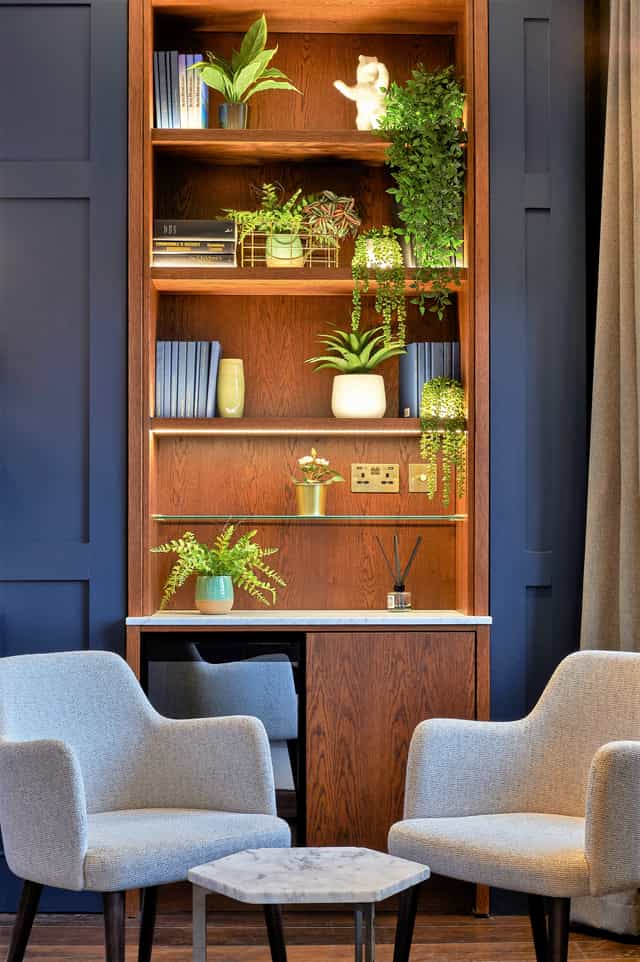 Stylish meeting space at The Shaftesbury with wooden shelves and greenery for events.