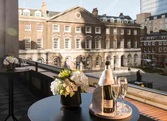 Elegant event space with balcony, flowers, ideal for networking and receptions.