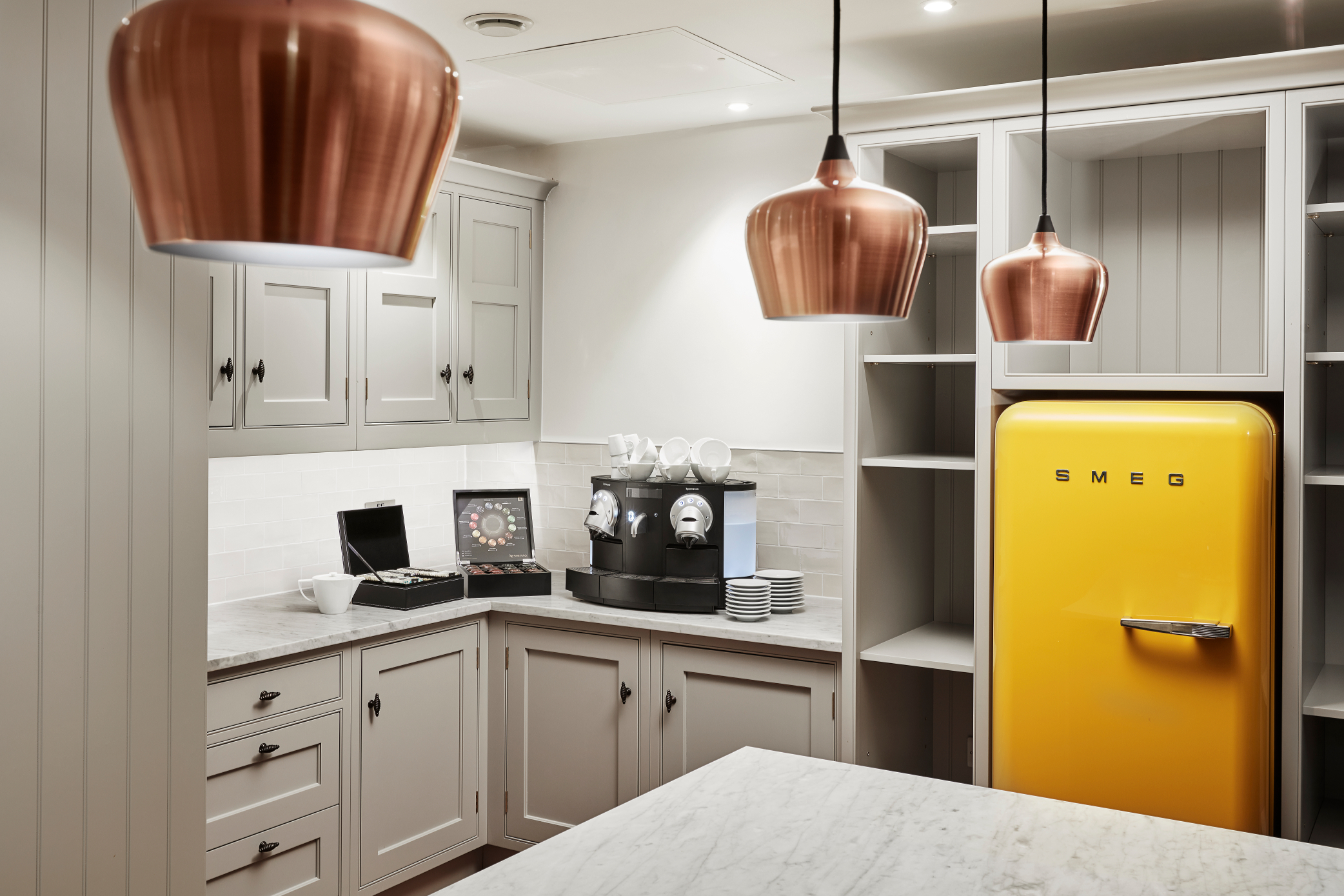 Stylish kitchenette in Marlin Waterloo, featuring a yellow SMEG fridge for events and meetings.