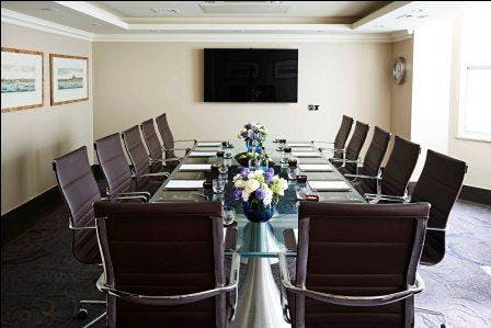 Modern conference room with glass table at Radisson Blu Hotel, ideal for corporate events.