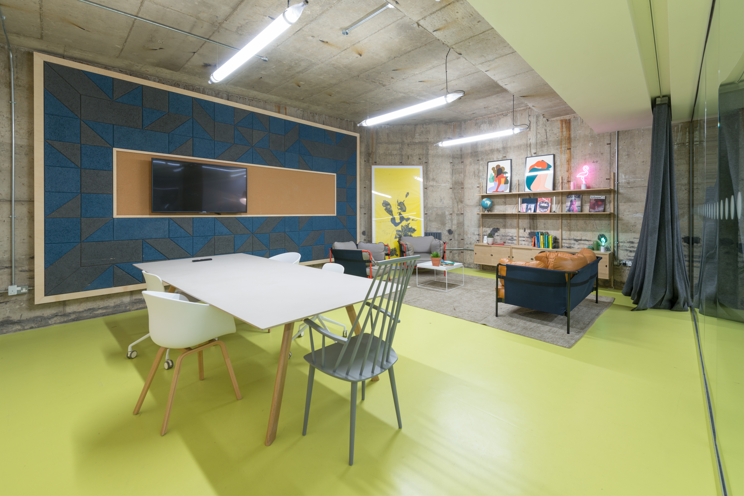 Modern meeting room with yellow flooring, ideal for brainstorming and team collaboration.