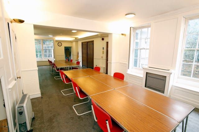 Ground Floor Salisbury Room with long table and red chairs for meetings and workshops.