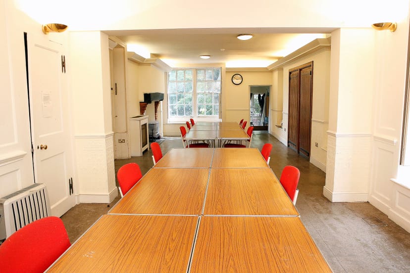 Ground Floor Salisbury Room with long table and red chairs, ideal for meetings and workshops.