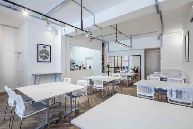 Versatile meeting space with modular tables and natural light for workshops and gatherings.