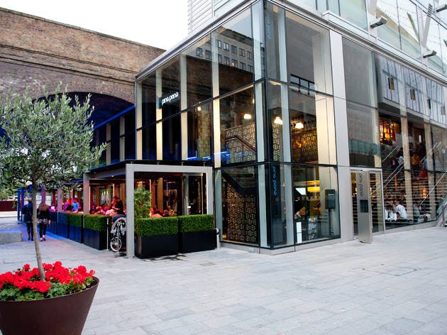 Modern glass venue with outdoor seating, ideal for corporate events and social gatherings.