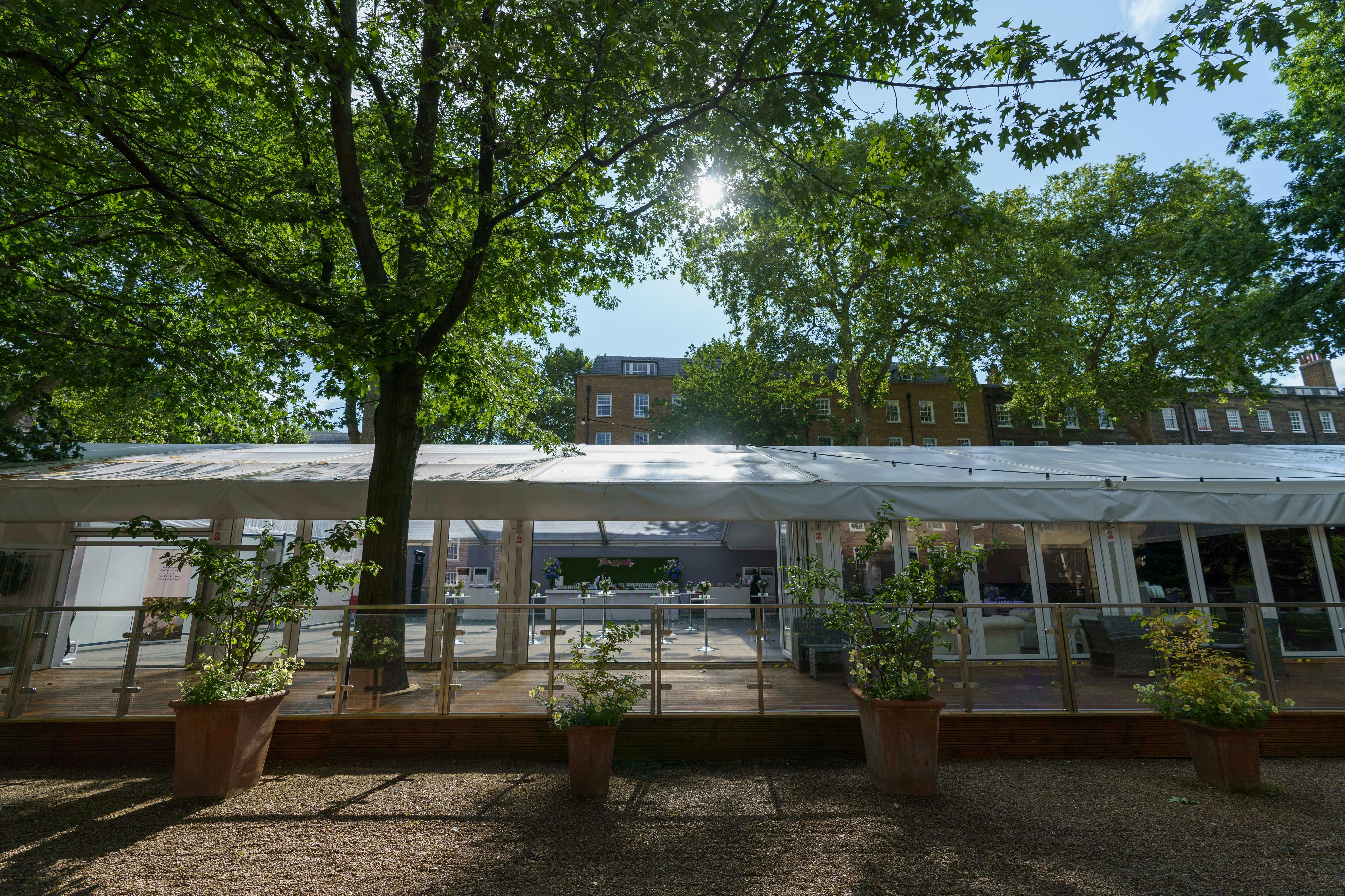 Summer party in a marquee at Gray's Inn, surrounded by greenery and natural light.