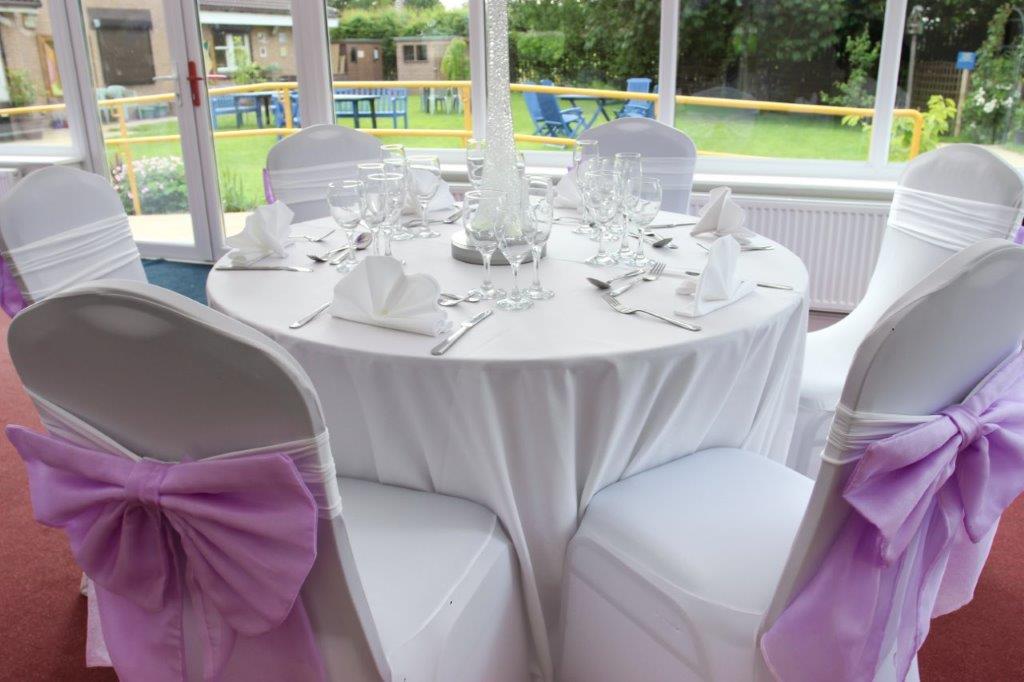 Iris Conservatory table setting with lavender bows, perfect for weddings and formal events. - Banner