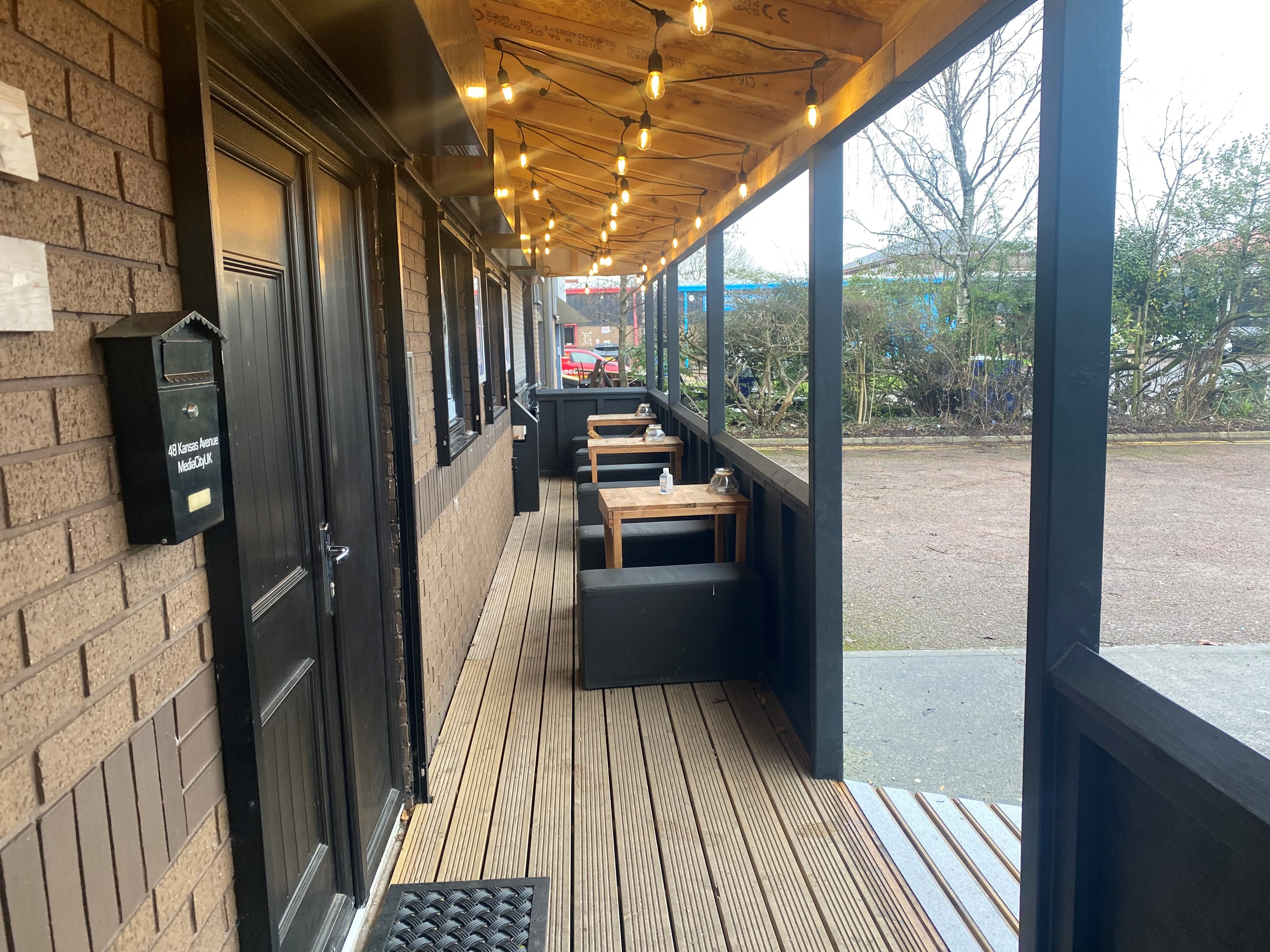 Charming outdoor venue with warm lighting for casual meetings and networking events. - Banner