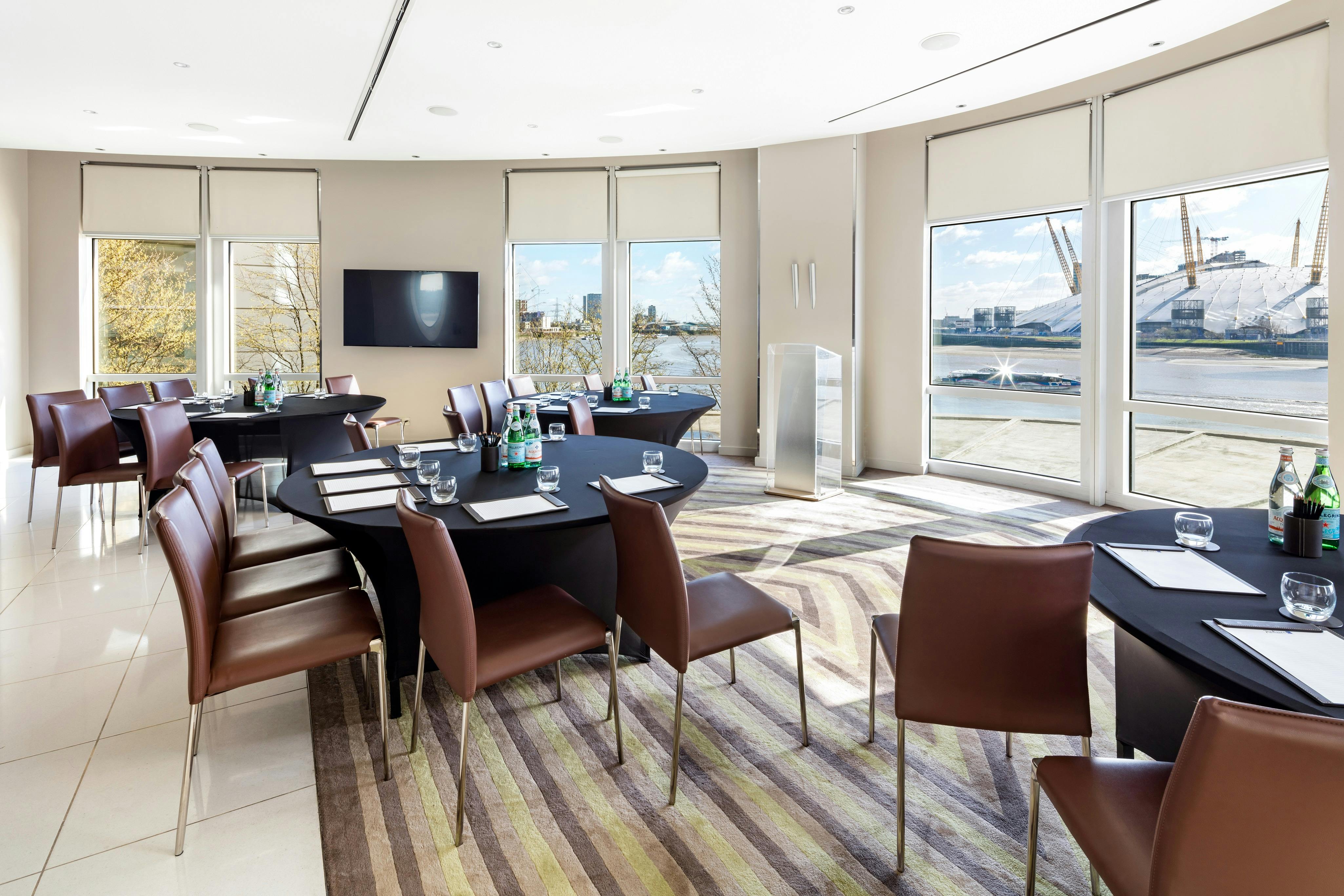 Modern meeting room with round tables at Radisson Blu Edwardian, perfect for corporate events.