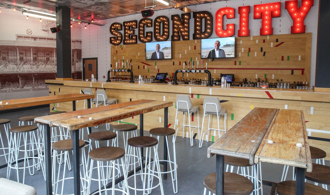 Vibrant event space at Second City with stylish bar, ideal for networking and gatherings.