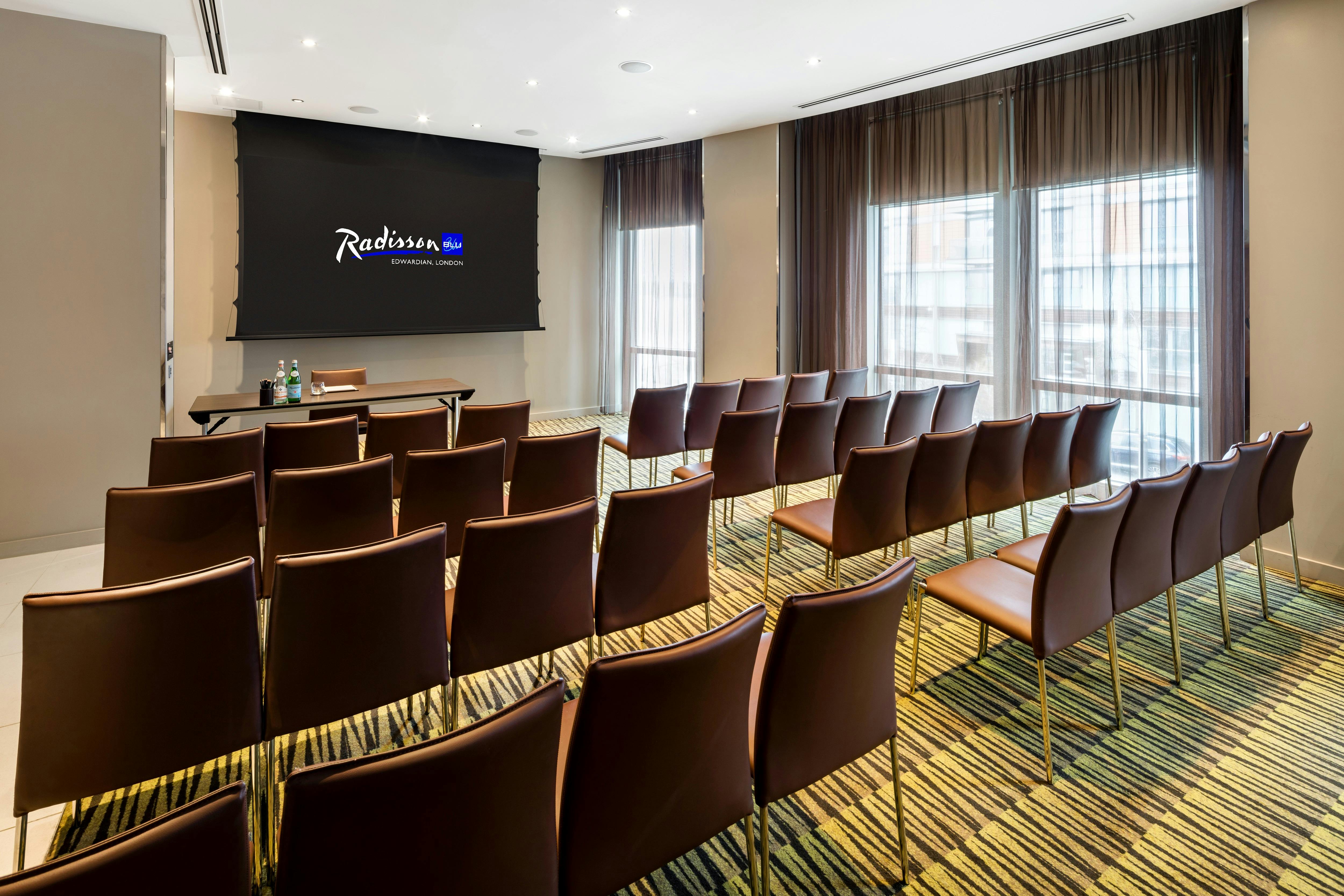 Private Room 1 at Radisson Blu: modern meeting space with theater seating, ideal for workshops.