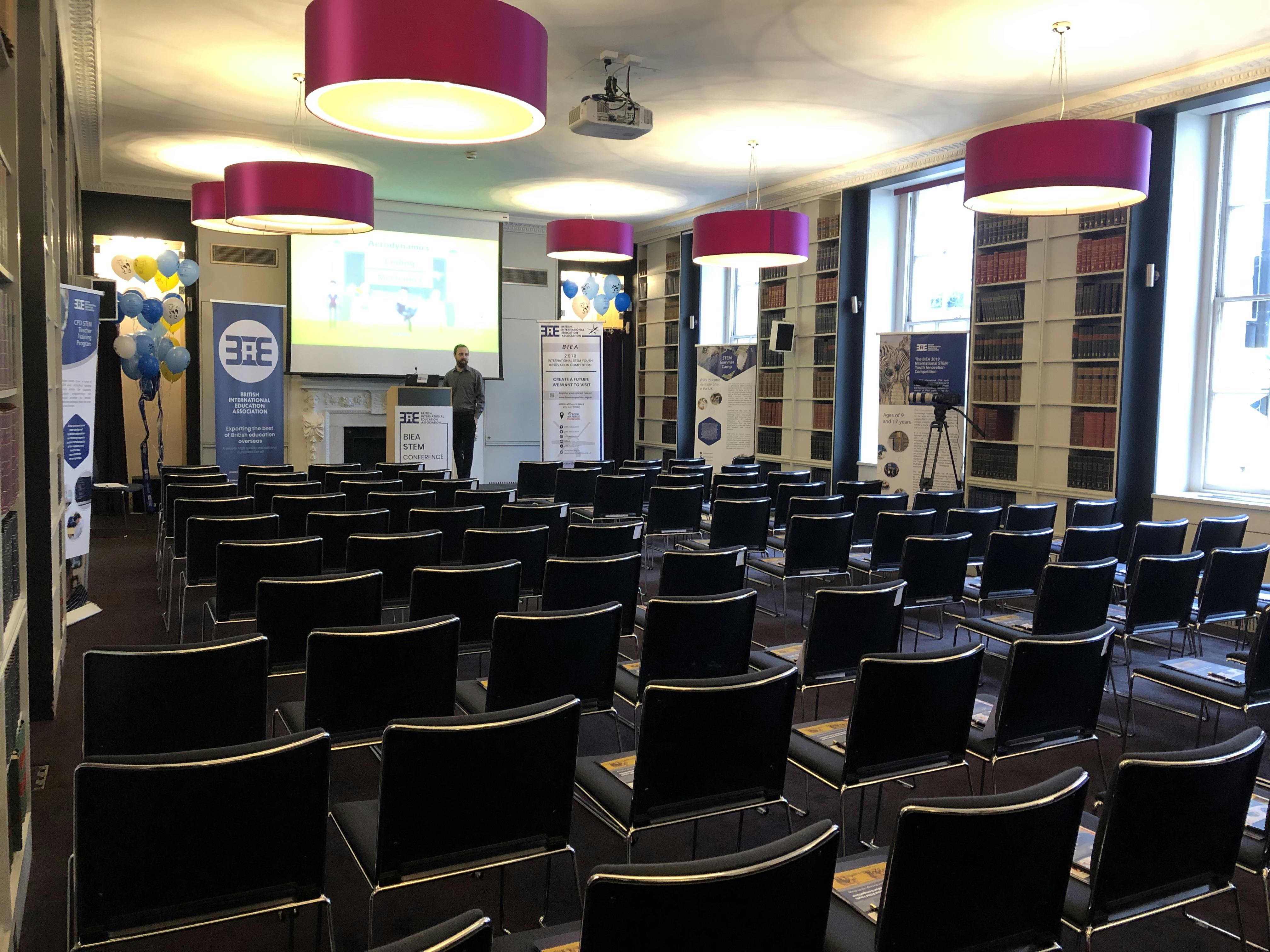 Event space with black chairs and presentation screen for corporate seminars.