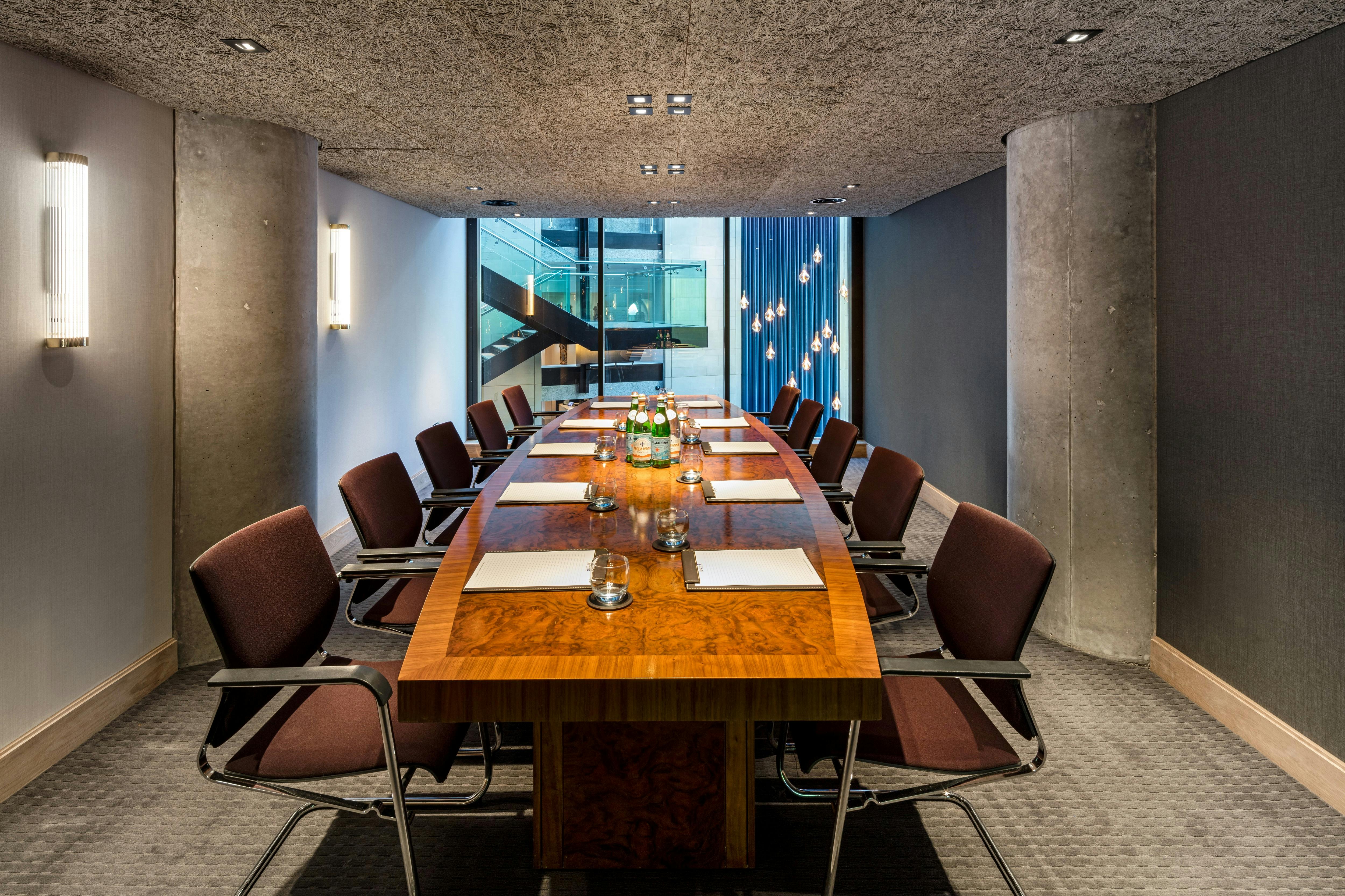 Modern conference room with wooden table and ergonomic chairs at The Edwardian Manchester.