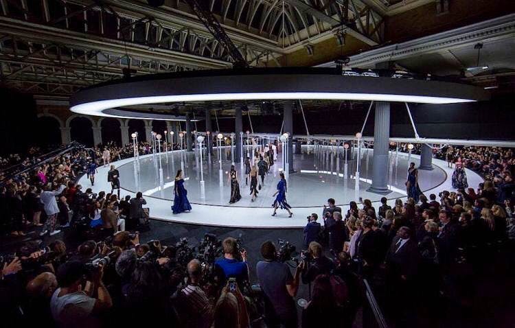 "Grand Hall at Old Billingsgate fashion event with circular runway and dramatic lighting."