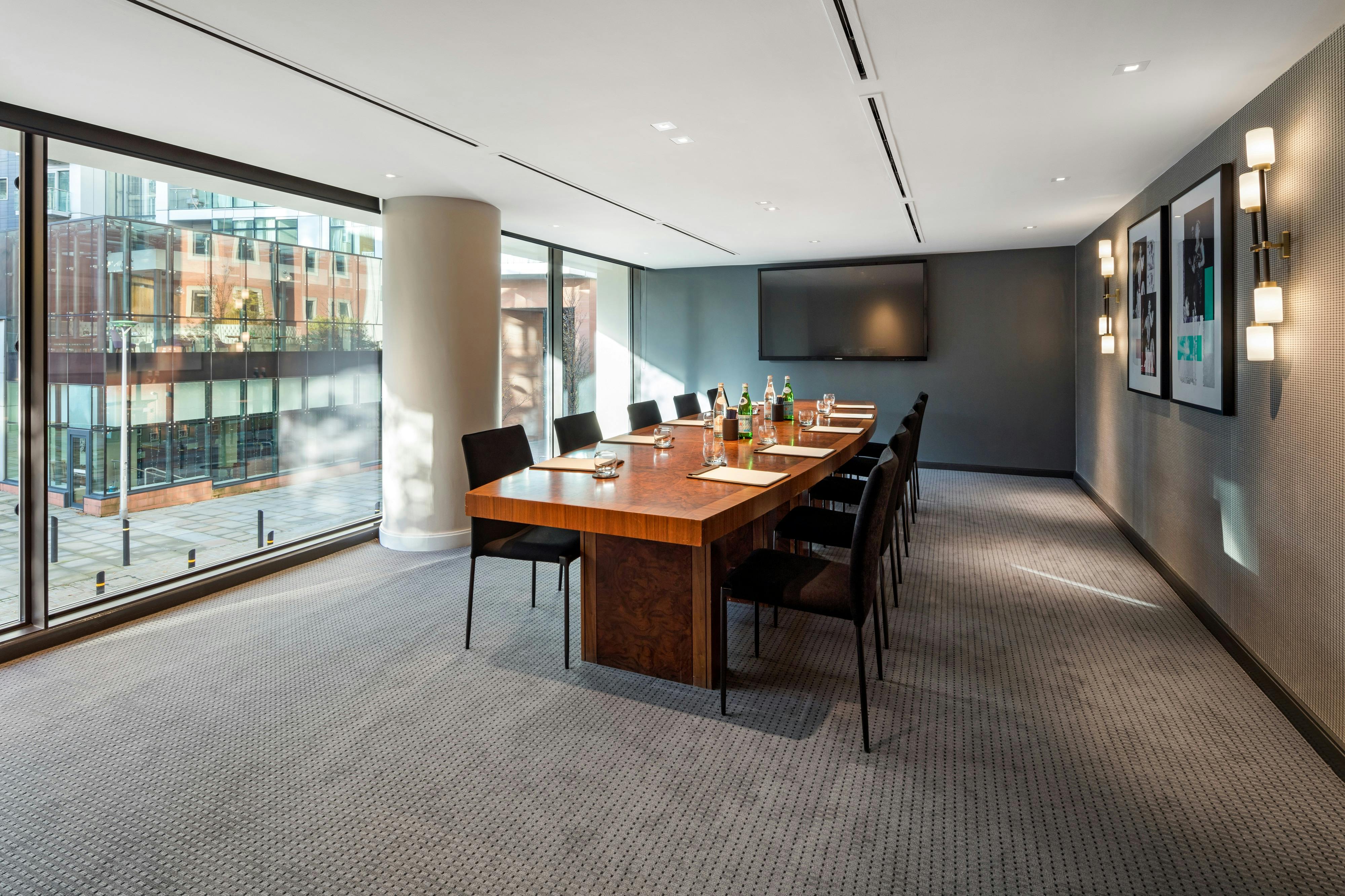 Modern meeting room with large table and natural light for corporate events.