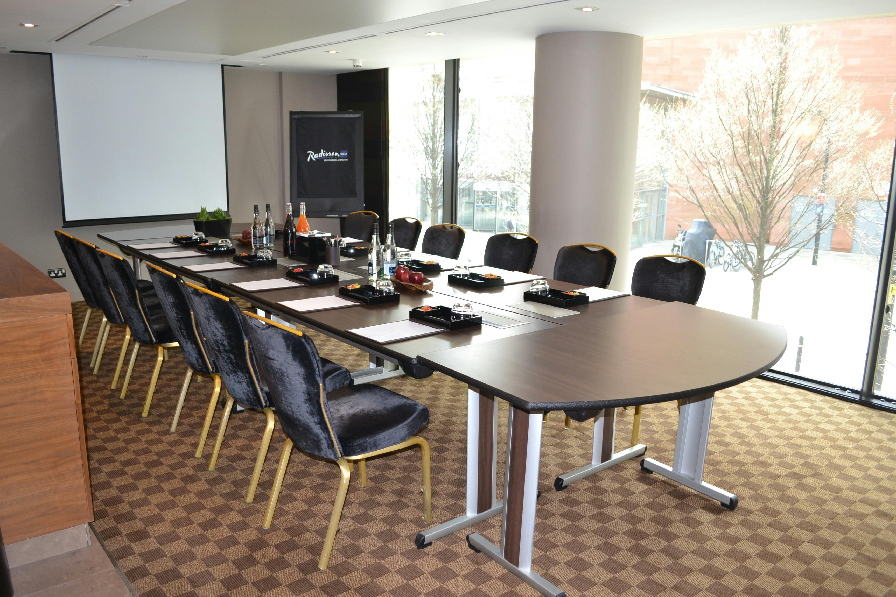 Meeting room at Peterloo Hotel, featuring a long table and natural light for events.