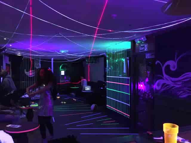 Vibrant event space at Moustache Bar Dalston with colorful laser lights for lively parties.
