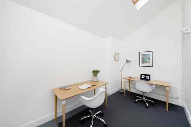 Minimalist meeting room with natural light, ideal for small brainstorming sessions.