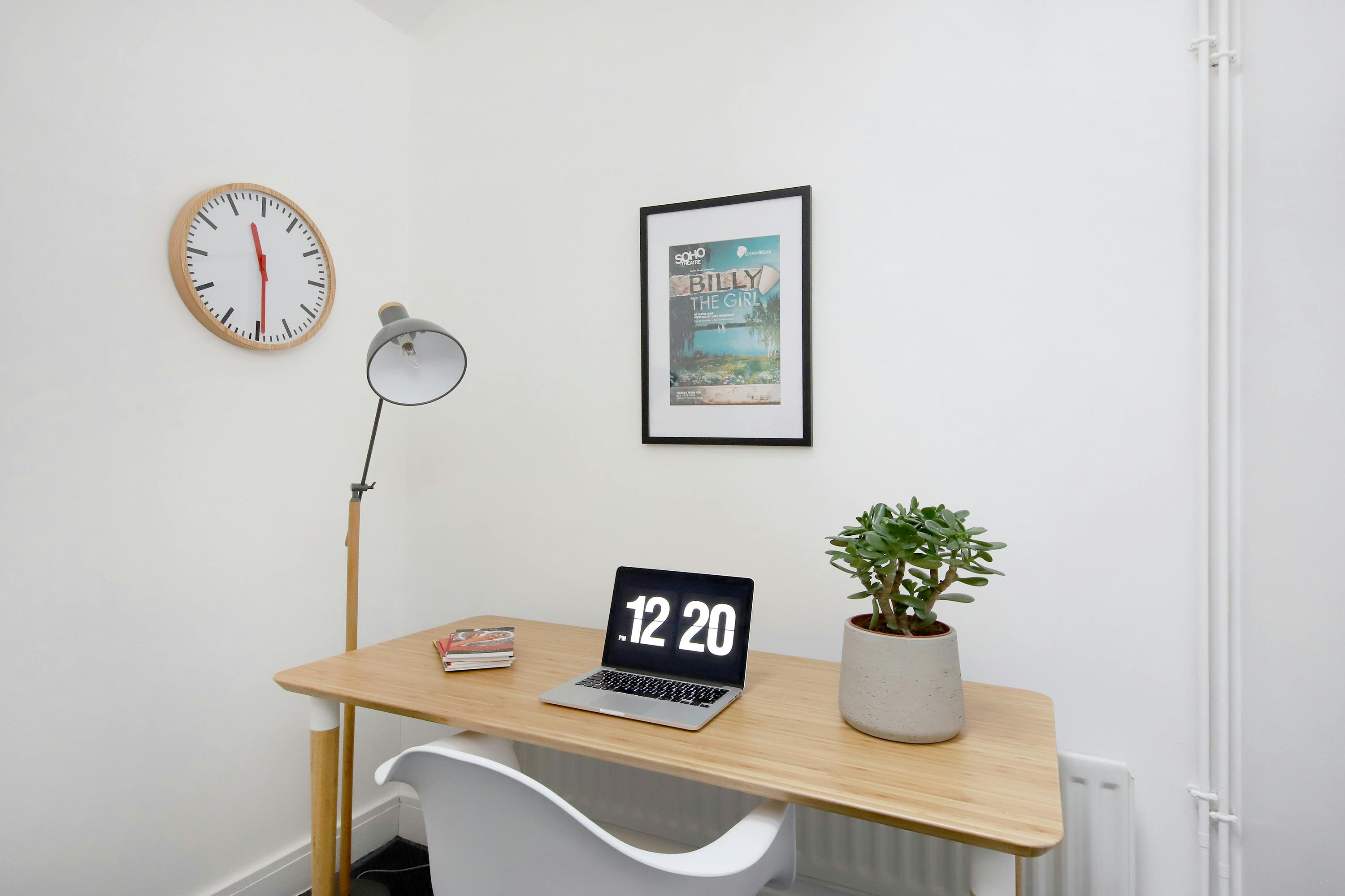 Minimalist meeting room with laptop and plant, perfect for virtual sessions and brainstorming.