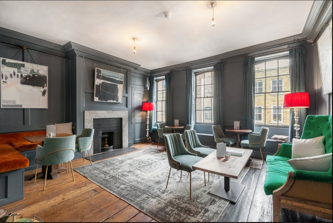 Stylish meeting space in Blacks with cozy seating and vibrant red lamps for events.