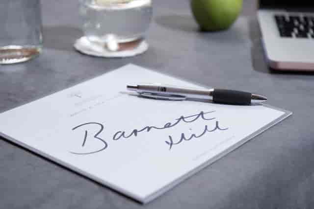 Garden Suite at Barnett Hill Hotel with meeting setup, notepad, and modern tech.