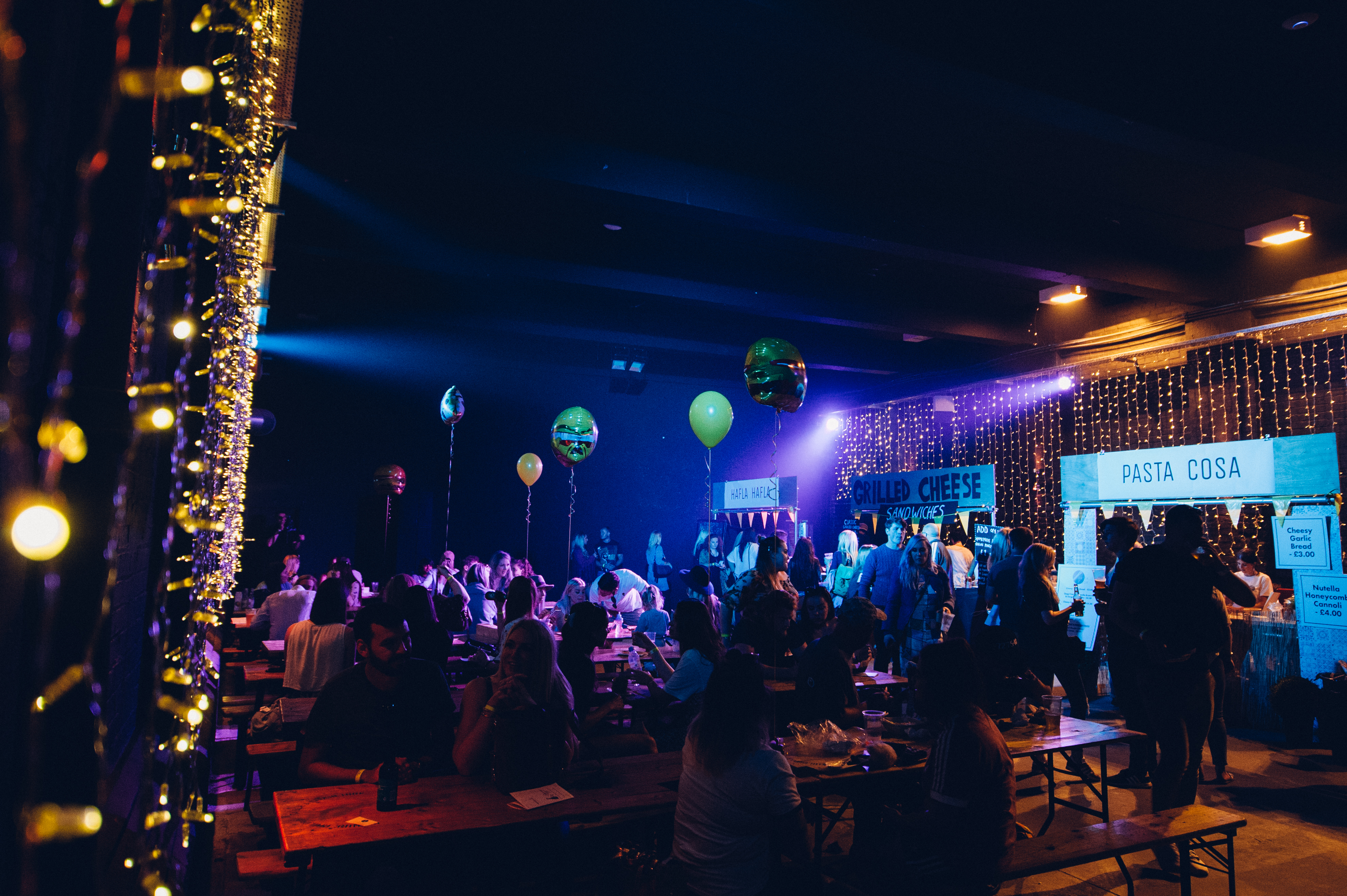 Eclipse Theatre event space with twinkling lights and colorful balloons for networking. - Banner
