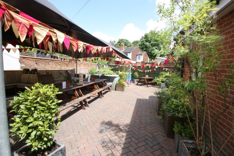 Charming outdoor event space with vibrant bunting for summer gatherings and team-building.