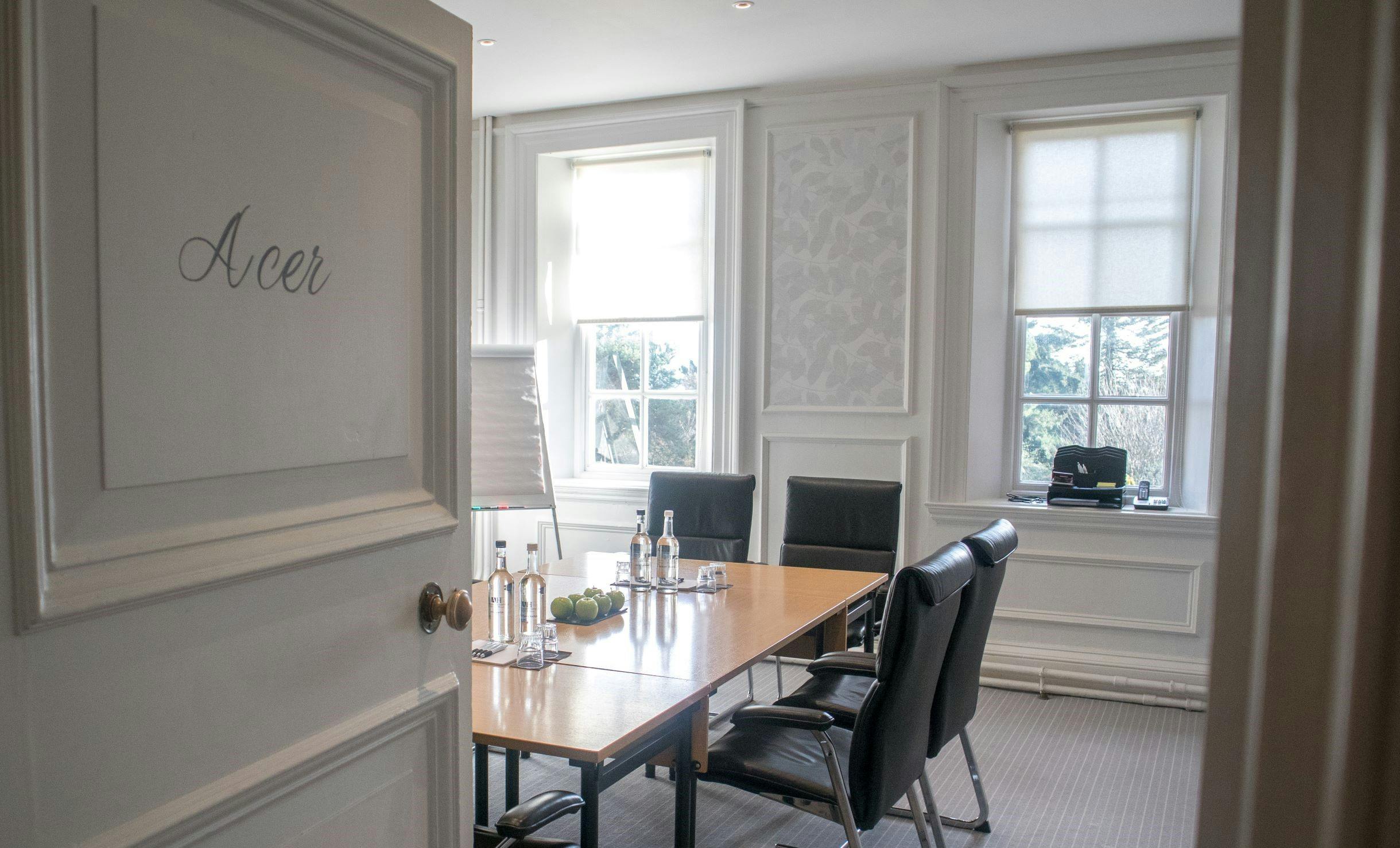 Acer meeting room at Barnett Hill Hotel with polished table and natural light, ideal for workshops.