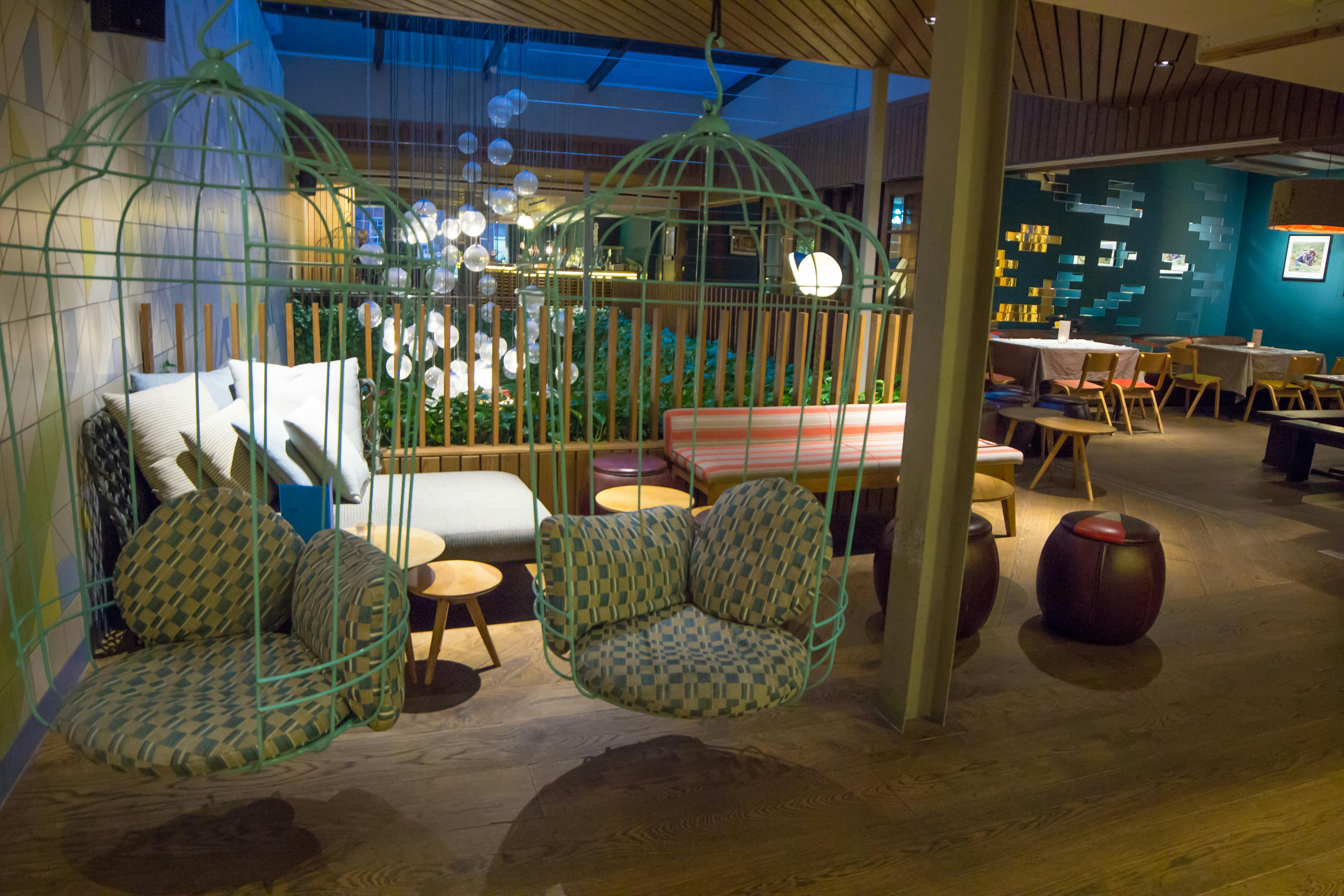 Stylish lounge with hanging chairs for networking events at Mezcaleria Bar.