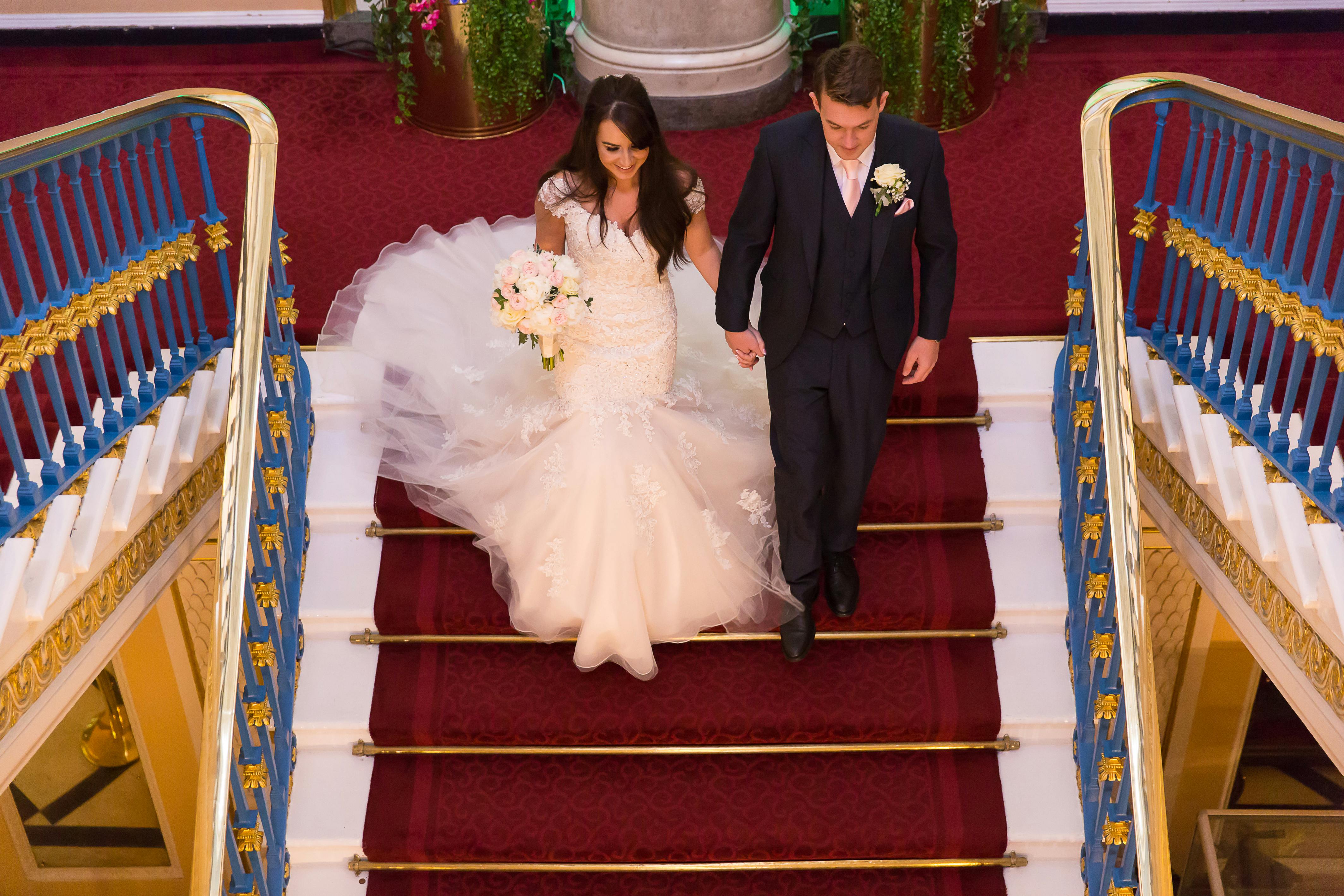 Couple descending staircase in Liverpool Town Hall's Main Ballroom, perfect for weddings.