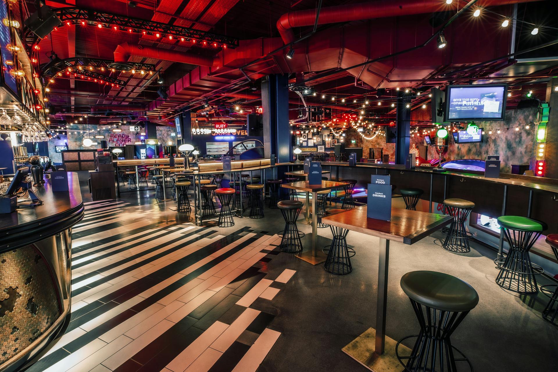 Emerald Area at Puttshack White City, vibrant event space with piano key flooring.