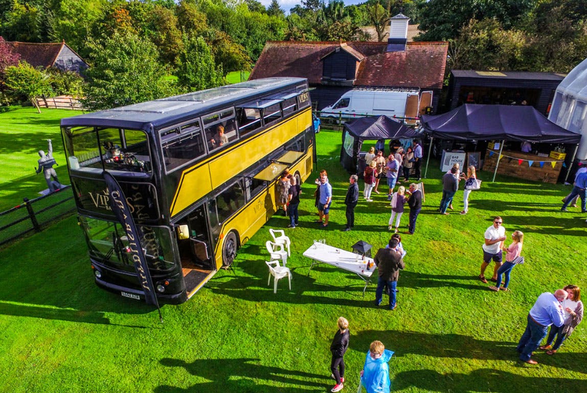 Stylish double-decker bus at vibrant outdoor event for creative gatherings and networking.