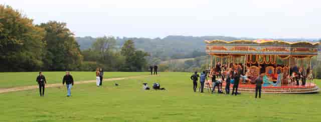 Outdoor event setup with carousel in lush greenery, perfect for memorable gatherings.