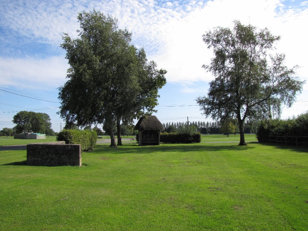 Serene outdoor event venue with lush grass and rustic charm in South England.