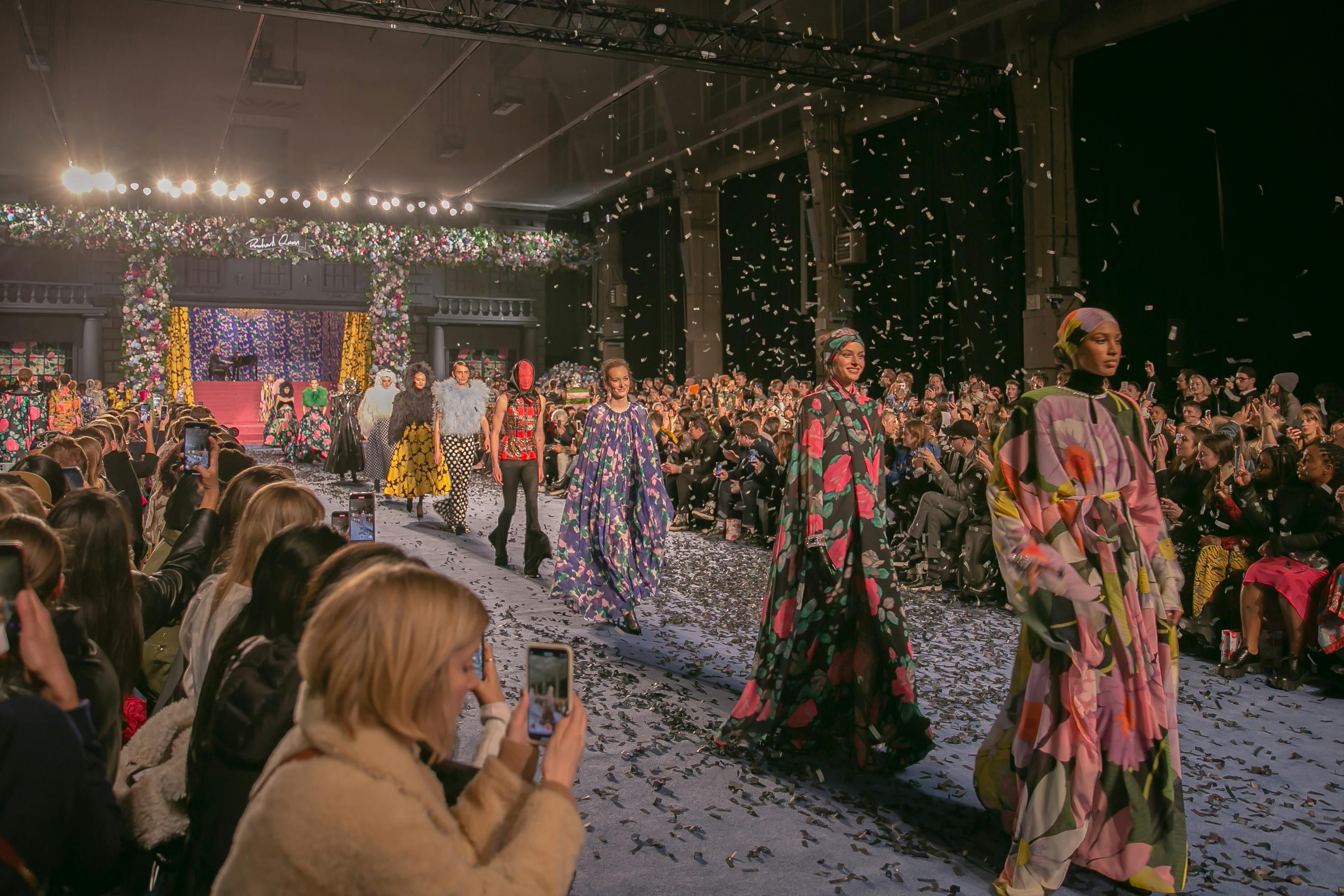 Fashion runway event at Lawrence Hall with colorful attire and engaged audience.