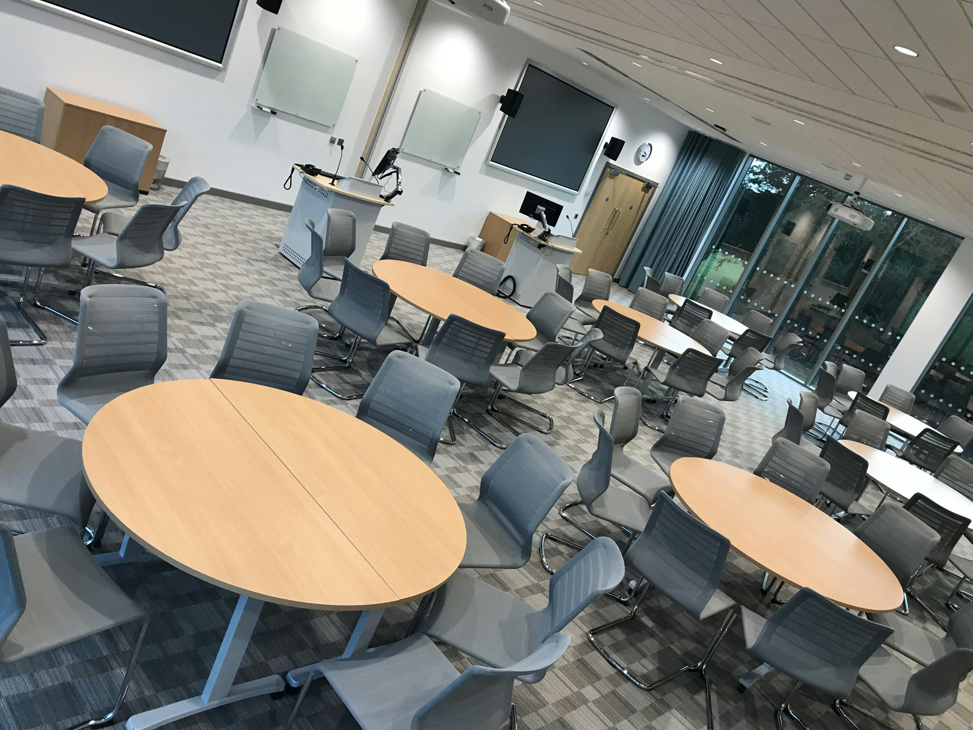 Versatile meeting space with round tables, ideal for workshops and team-building events.