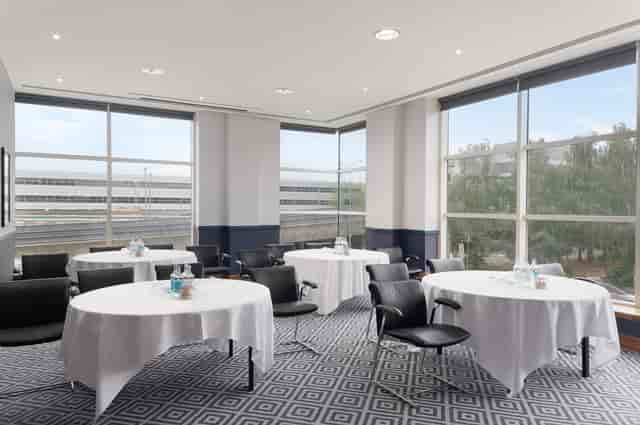 Marcel in a bright Sofitel London Gatwick meeting room with round tables for workshops.