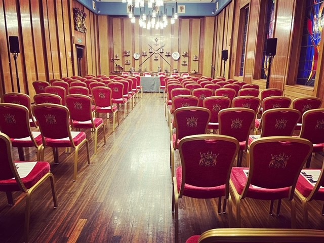 Elegant red chairs in The Livery Hall, perfect for conferences and seminars. - Banner