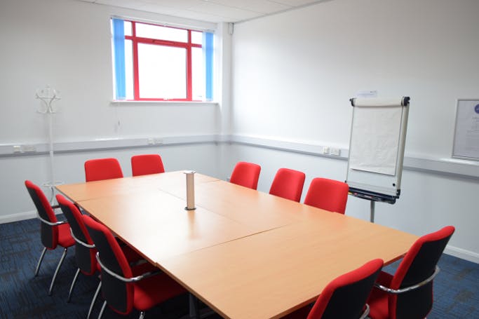 Meeting Room 4 at HAD with a large table, red chairs for collaborative meetings.