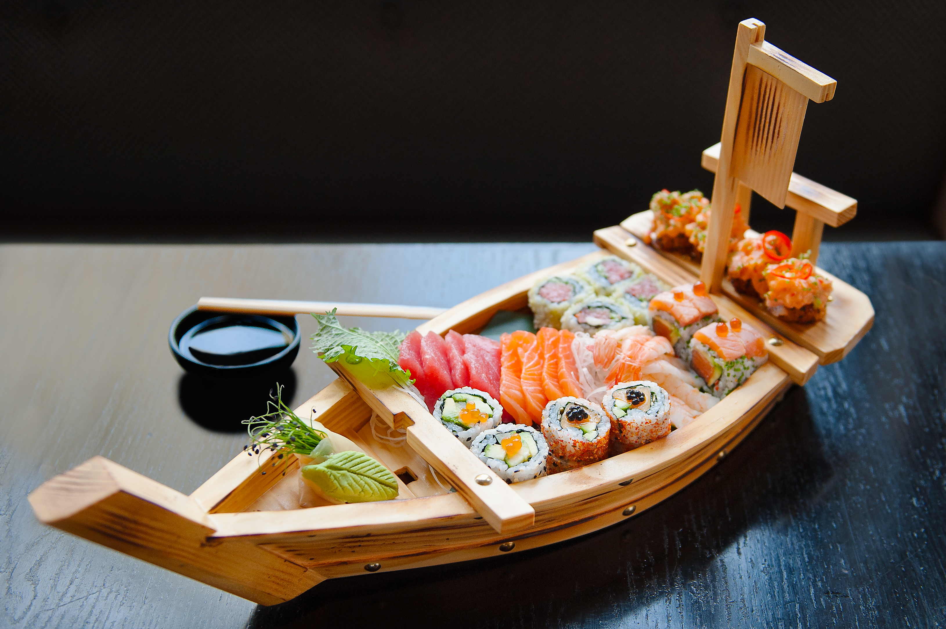 Sushi platter on wooden boat in E&O's private dining room for events and receptions.